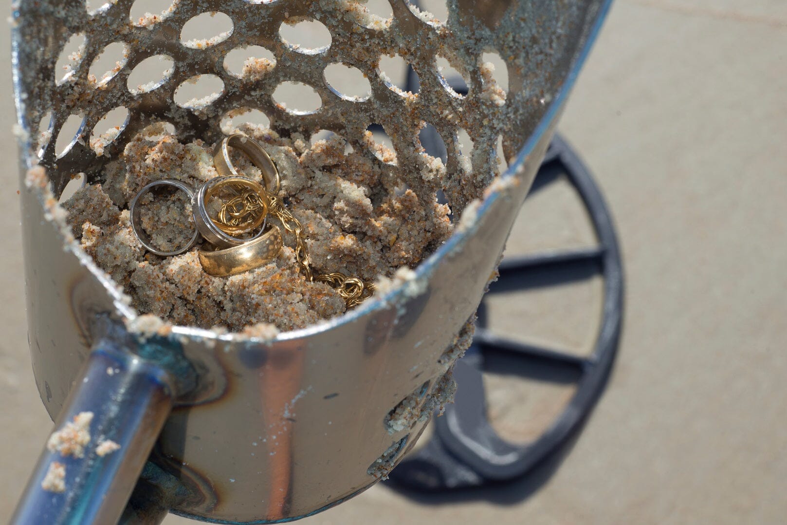 beach metal detecting sand scoop with jewelry in it