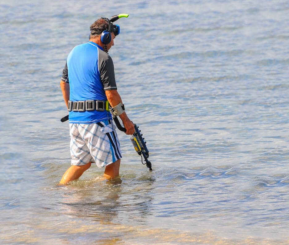 man metal detecting with waterproof metal detector