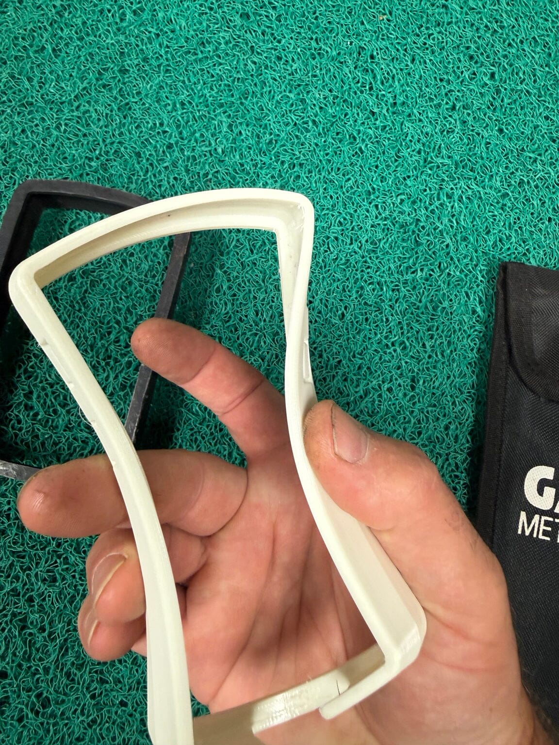Used white soft 3D-printed Equinox 600 800 protective bumper in hand